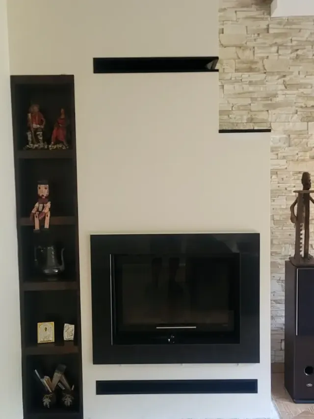 Kominek w jasnej nowoczesnej zabudowie z czarnymi detalami — realizacja MAS Kominki