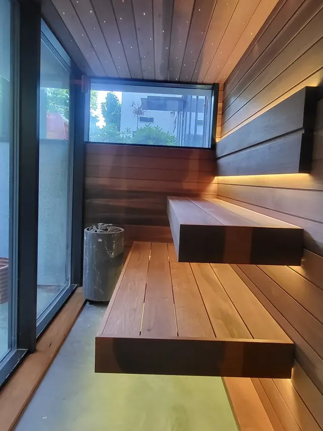Nowoczesna sauna z dużym przeszkleniem i podświetlanymi ławami — realizacja MAS Kominki