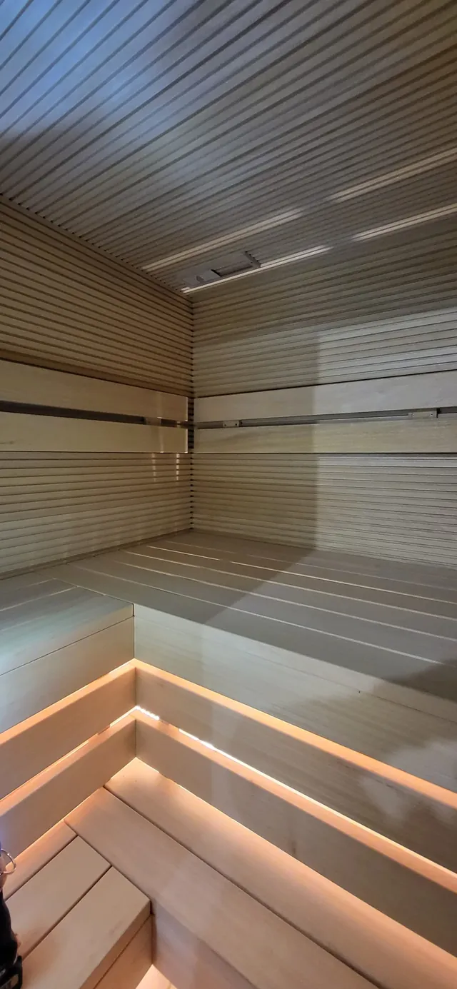 Sauna z nastrojowym oświetleniem pod drewnianymi ławami — realizacja MAS Kominki